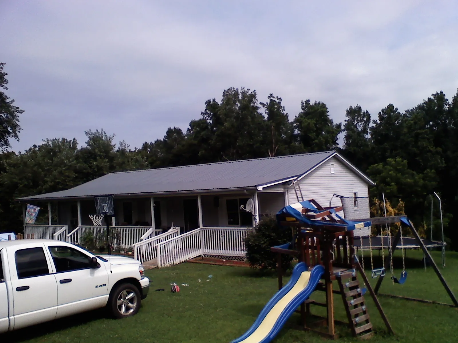Dark metal roof on a country home with a full length front porch in Palatine