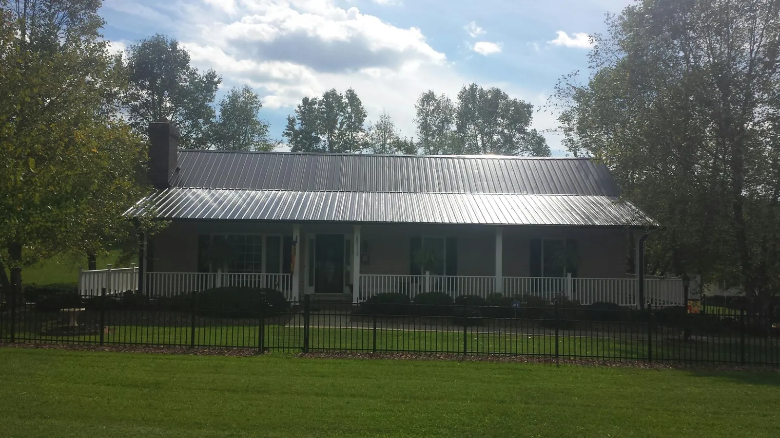 Gray metal roof on a brick ranch with a full width front porch — Gutter Guard Installation work by our crew in Palatine
