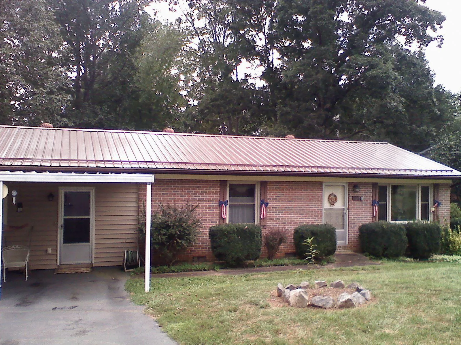 Bronze metal roof and carport on a brick ranch home — Roof Repair work by our crew in Palatine